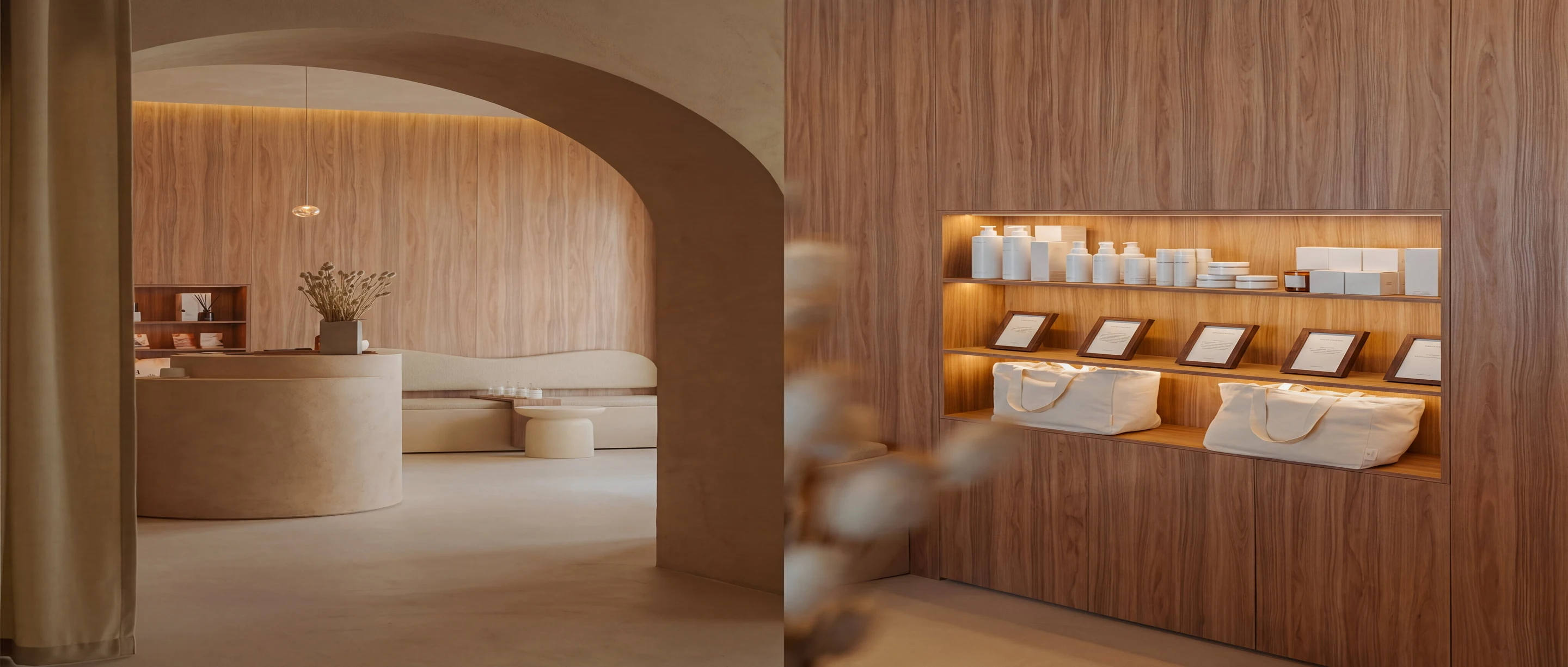 Moderno studio Pluma con muebles redondeados en beige, un banco, una mesita y una estantería de madera con bolsas y productos decorativos.