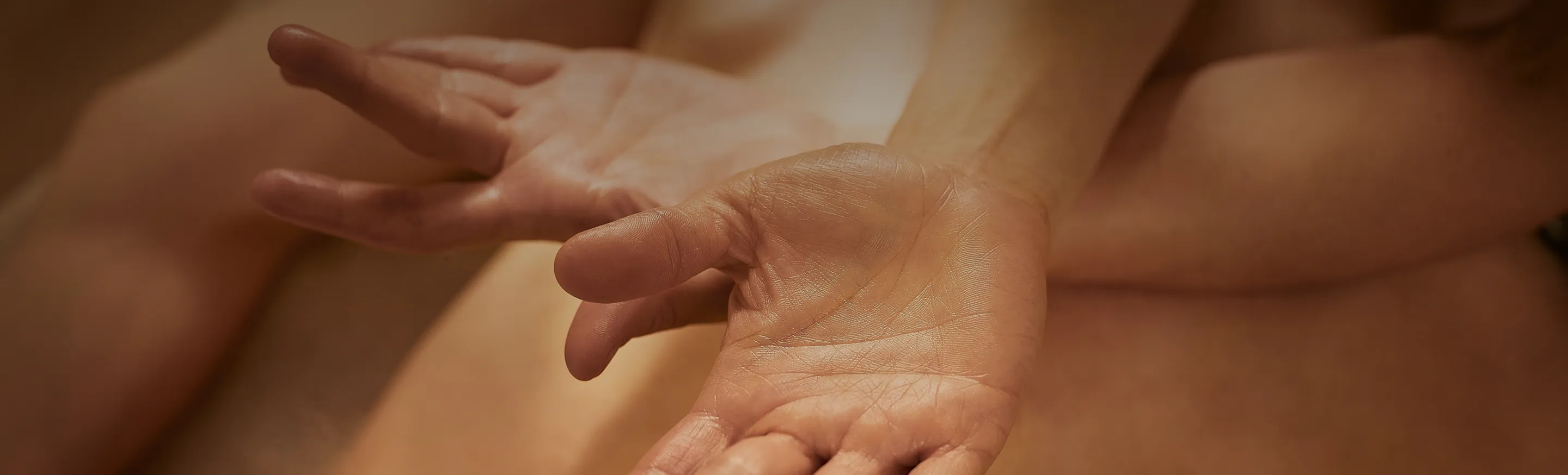 Primer plano de dos manos ligeramente abiertas dando un masaje wellness.
