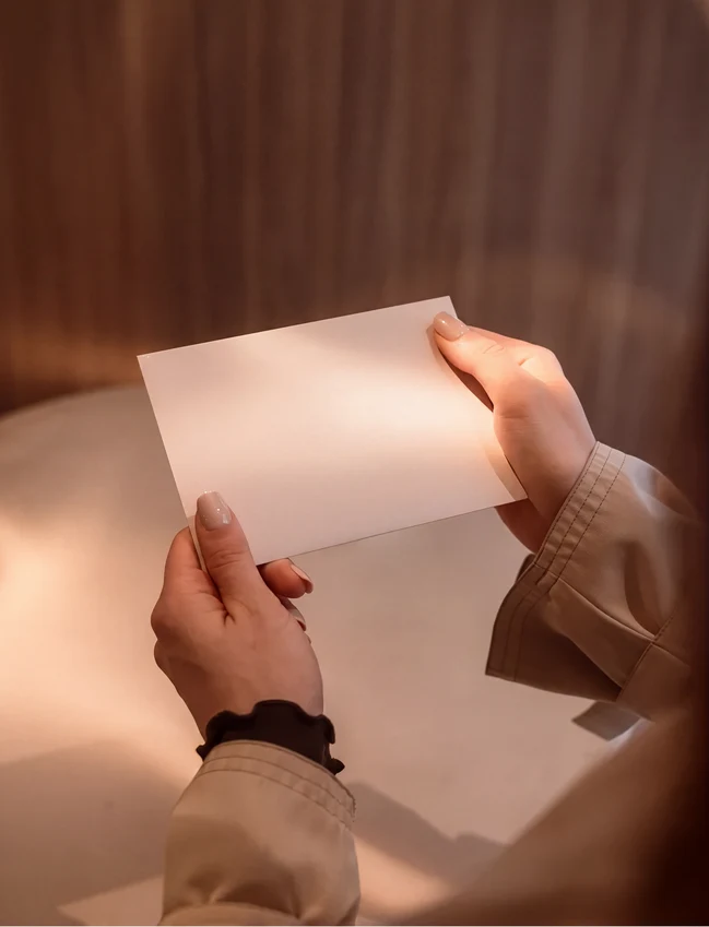 Persona sostiene una tarjeta regalo con la inscripción 'Pluma' y 'be good to yourself'.