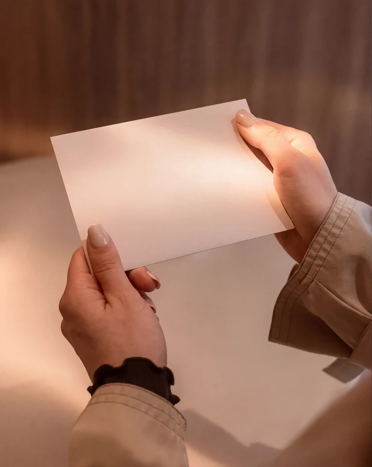 Una persona sostiene un vale con la inscripción 'Pluma' y el texto 'be good to yourself'.